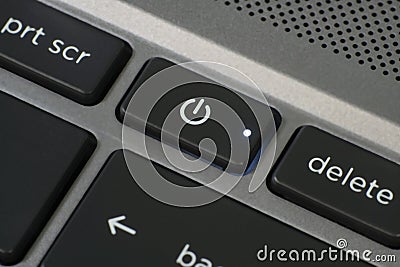 Close up of laptop power button with illuminated LED. Stock Photo