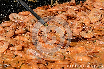 Close up of a large portion of shrimps prepared with red sauce of tomatoes and cream, ready to eat at a street food market Stock Photo