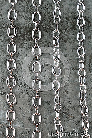 Close up of large shiny metalic silver chains on gray texture background top view Stock Photo