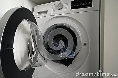 Close-up of a Siemens brand washing machine with the door open with dirty laundry Editorial Stock Photo