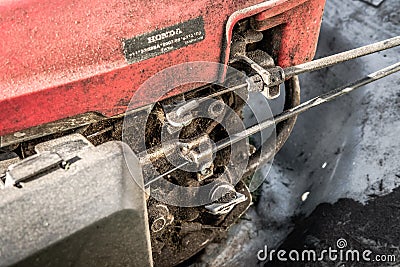 Close-up of a lawn petrol mower showing the throttle and clutch linkages. Editorial Stock Photo