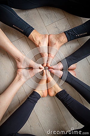 Close up legs of people sitting on the gym floor in a circle together. Stock Photo