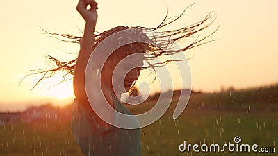 CLOSE UP Joyful blonde girl enjoys her evening in countryside by dancing in rain Stock Photo