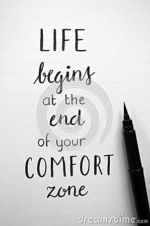 Close-up of `LIFE BEGINS AT THE END OF YOUR COMFORT ZONE` hand-lettered in notebook Stock Photo