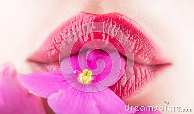 Close-up lips and flower. Close-up beautiful female lip with bright lipgloss makeup. Spa and cosmetics. Lips with Stock Photo
