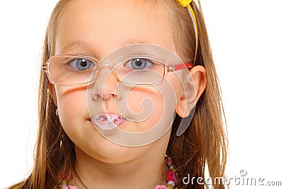 Close up little girl in glasses doing fun saliva bubbles Stock Photo