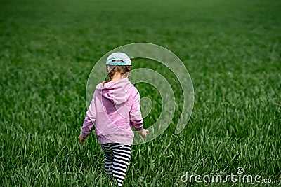 Close-up of a little girl lost, walking across a field Stock Photo