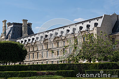 Close-up of Louvre palace with park, Pavillon de Marsan, lawn and flowers at hot sunny day. Paris - France, 31. may 2019 Editorial Stock Photo