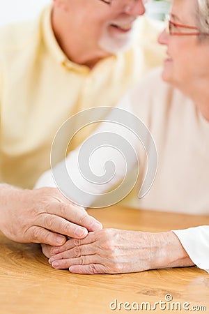 Close-up of lovely senior couple holding hands. Focus on the han Stock Photo