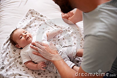 Close Up Of Loving Father Lying With Newborn Baby On Bed At Home In Loft Apartment Stock Photo