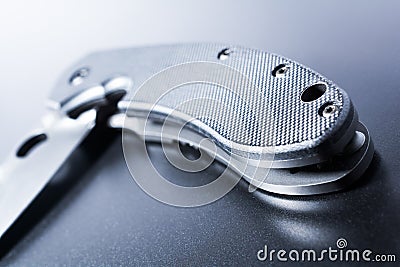 Close Up Of A Lying Half Opened Faint Military Knife On Dark Ground Stock Photo