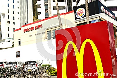 Close-up of a MacDonald sign, next to a fastfood burger king Editorial Stock Photo