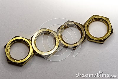 Close-up macro of four arranged gold hexagonal screw nuts isolated on white background Stock Photo