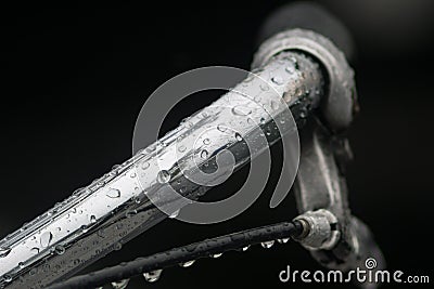 Close up / Macro image of bicycle handlebar in the rain with lots of water droplets on the steel. Stock Photo