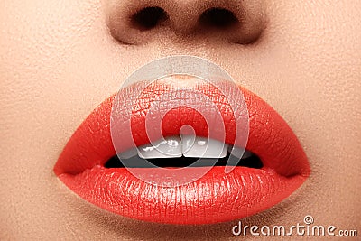 Close-up macro shot of female mouth. Glamour red lips Makeup with sensuality gesture. Orange colour Stock Photo