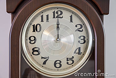 Close up macro view of brown clock with light clock face showing twelve o`clock. Time concept. Postcard. Stock Photo