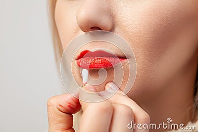 Close-up of the make-up of the lips of a model with a light-colored face, the make-up artist holds a cotton swab in his hands and Stock Photo