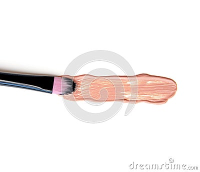 Close-up of makeup brush with smeared liquid foundation on white background. Top view. Stock Photo