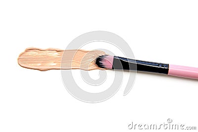 Close-up of makeup brush with smeared liquid foundation on white background. Top view. Stock Photo