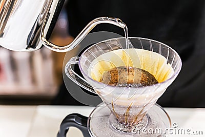 Close-up making pour-over coffee with alternative method called Dripping. Coffee grinder, coffee stand and pour-over. Stock Photo