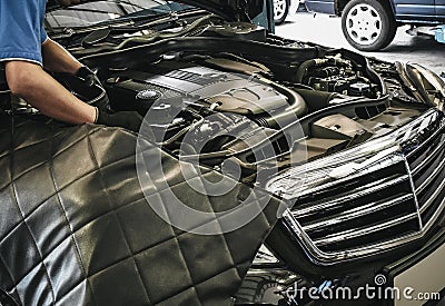 Close up of male auto mechanic working on engine in auto repair Stock Photo