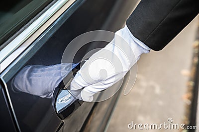 Male Chauffeur Opening Door Of Car Stock Photo