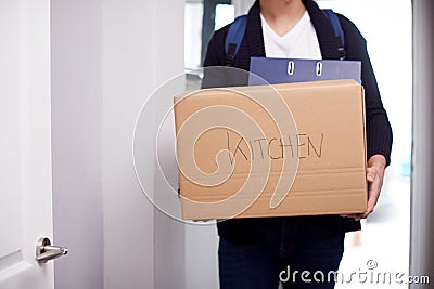 Close Up Of Male College Student Carrying Box Labeled Kitchen Moving Into Accommodation Stock Photo