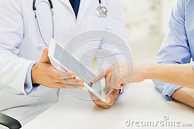 Close up of male doctor and patient with tablet pc Stock Photo