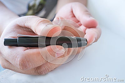 Close up of male finger patient pricking his finger to draw a d Stock Photo