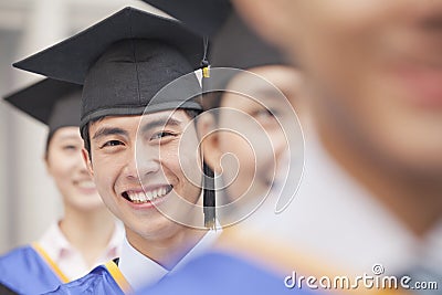 Close Up of Male Graduate Student Standing in a Row of Graduates Stock Photo