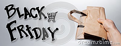 Close-up of male hand holding eco paper bag, black friday words isolated on white background. Stock Photo
