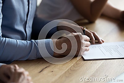 Close up male hand holding pen and signing legal document Stock Photo