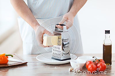 Close up of male hands grating cheese Stock Photo