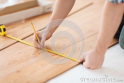 Close up of male hands measuring wood flooring Stock Photo