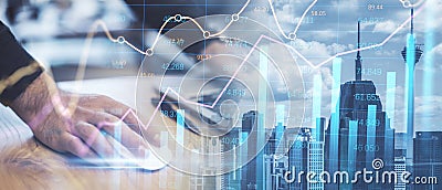 Close up of male hands using laptop mouse while leaning on desk on abstract wide city background with forex chart and grid. Stock Photo