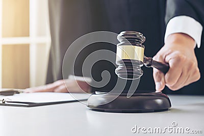 Close up of Male lawyer or judge hand`s striking the gavel on so Stock Photo