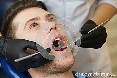 Close-up of male with open mouth during oral checkup at the dentist Stock Photo