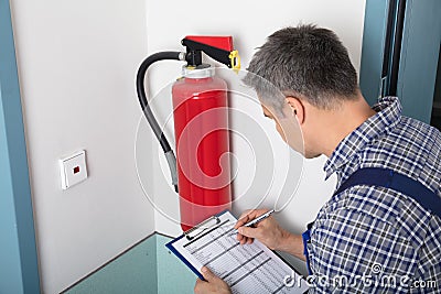 Professional Checking A Fire Extinguisher Stock Photo