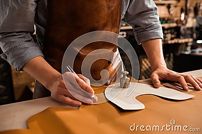 Close up of a male shoemaker cutting leather textile Stock Photo