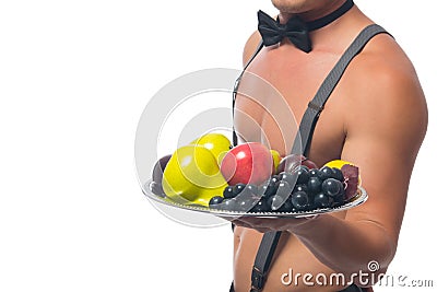 Close-up, a male waiter with a bare torso, holding a tray of fruit in his hand, on a white background, there is a place for the Stock Photo