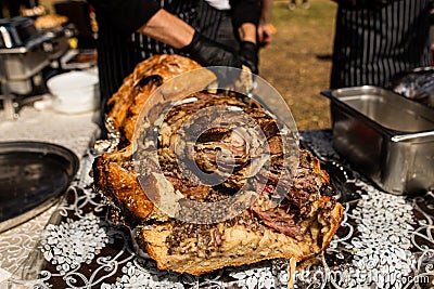 Close up of man in black gloves cook whole of lamb Stock Photo