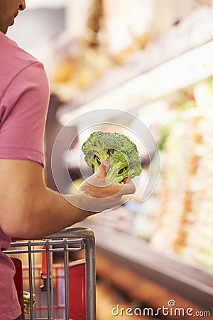 Close Up Of Man Choosing Broccoli In Supermarket Stock Photo