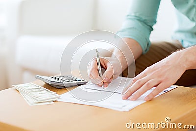 Close up of man counting money and making notes Stock Photo