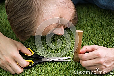 Man Using Measuring Scale While Cutting Grass Stock Photo