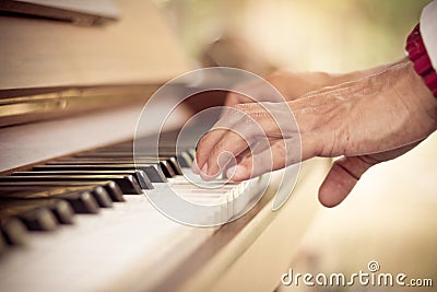 Close up man hand musician playing piano vintage tone. Stock Photo