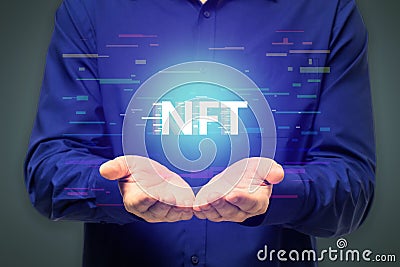 Close up of man hands holding creative glowing NFT hologram on dark background. Non-fungible token concept Stock Photo