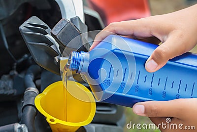 Close up on man hands. Mechanic pouring new engine oil to motorcycle engine Stock Photo