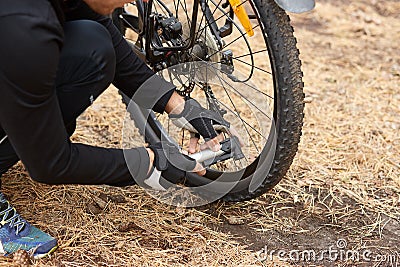 Close up of man hands pumping bicycle wheel, home maintenance of bike, bicycle service and maintaining for new season, faceless Stock Photo