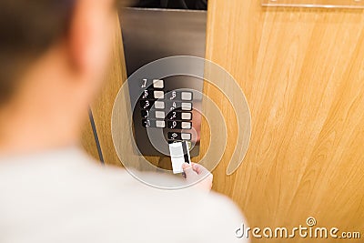 Close up of man holding cardkey on control panel elevator access concept Stock Photo