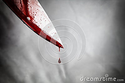 close-up of man holding knife smeared with blood and still dripping. Stock Photo